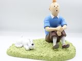 a figurine of a man and a dog on the grass