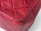 a close up of a red chanel bag on a white background