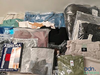 une pile de vêtements posée sur un lit