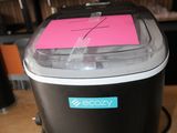 a black and white ice cream maker with a pink sticker on it