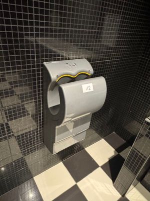 a toilet paper dispenser in a bathroom with a checkered floor