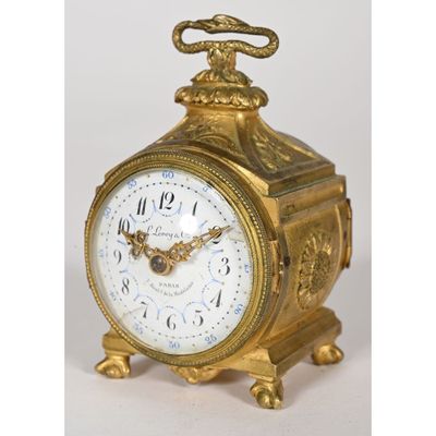 a gold clock with a bird on top of it