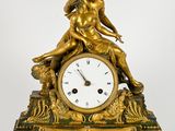 une horloge en or surmontée d'une statue