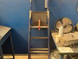 a ladder leaning against a blue wall in a room