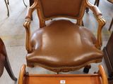 a brown leather chair and ottoman in a room