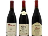 three bottles of wine are lined up on a white surface