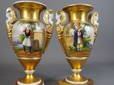 une paire de vases en or ornés d'une peinture représentant un homme et une femme