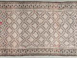 an old rug with a pattern on it on a white floor