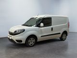La petite camionnette blanche est garée dans une grande pièce.