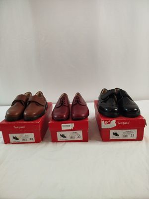 trois paires de chaussures pour homme se trouvent dans une boîte rouge