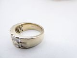 a gold ring with diamonds on it on a white surface
