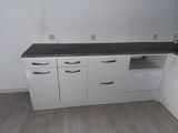 an image of a kitchen with white cabinets and a black counter top