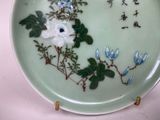 a plate with flowers and leaves on it on a table