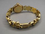 an image of a close up of a gold bracelet with a clock