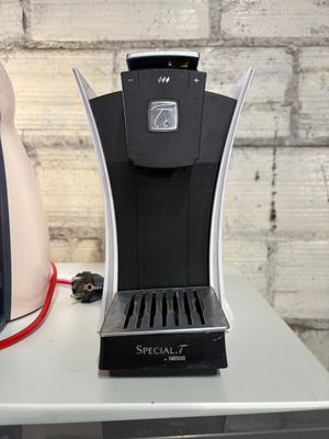 une cafetière posée sur une table, à côté d'un grille-pain