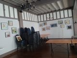 tables and chairs in a room with pictures on the wall