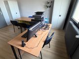 un bureau sur lequel se trouvent un ordinateur et une imprimante, dans une pièce