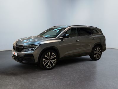 Un SUV gris est garé dans une pièce aux murs blancs.