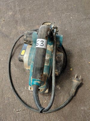 un petit compresseur d'air posé par terre à côté d'un cordon d'alimentation