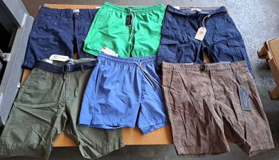 Plusieurs paires de shorts pour hommes sont alignées sur une table