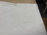 a piece of white fabric on a table next to a chair