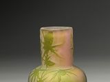 un vase vert orné d'un motif, posé sur une table