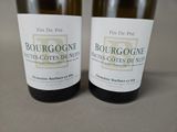 two bottles of wine sitting on top of a table next to each other