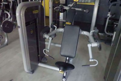 une photo d'une salle de sport avec un appareil et d'autres équipements