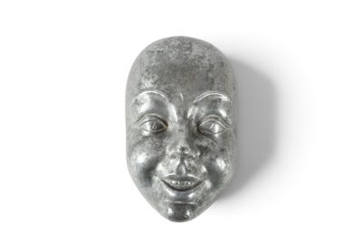 un masque argenté sur un fond blanc, arborant un sourire