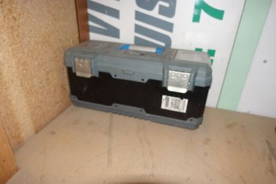 une petite boîte à outils posée sur une boîte en carton
