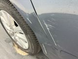 a close up of a car ' s front tire with a denting on it