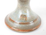 a close up of a vase on a white surface