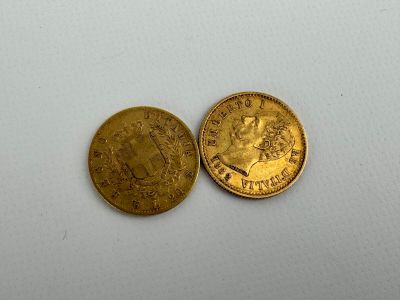 a close up of two gold coins on a white surface