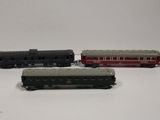 three toy trains are lined up on a white surface
