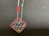 a close up of a necklace on a table with a tag on it