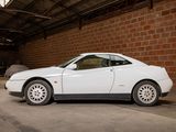a white car parked in a garage next to a brick wall