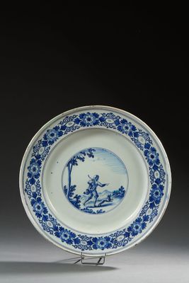 assiette bleue et blanche représentant un homme et une femme dans un bateau