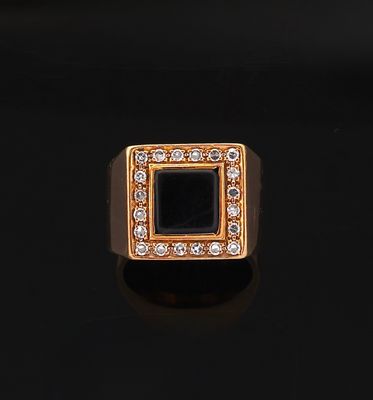 a gold ring with a black stone surrounded by white diamonds