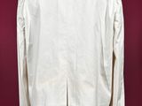 a white jacket on a mannequin stand against a red background