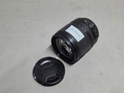 un objectif d'appareil photo posé par terre à côté d'un cache-objectif