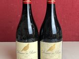 deux bouteilles de vin posées sur un comptoir à côté d'autres bouteilles de vin