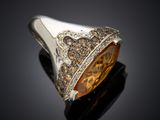 a close up of a ring with a large citrine stone in the center