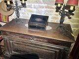 a wooden table with three candles on it and a picture on the wall behind it