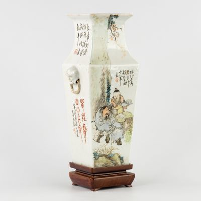 un vase blanc orné d'une peinture, posé sur un socle en bois