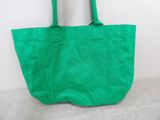 an image of a green tote bag sitting on top of a couch
