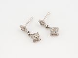 a pair of diamond earrings on a white background