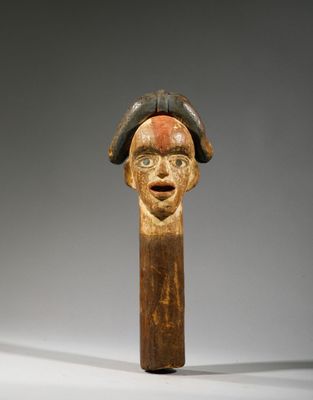 a close up of a wooden stick with a face on it