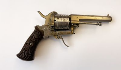 gros plan d'un revolver sur une surface blanche