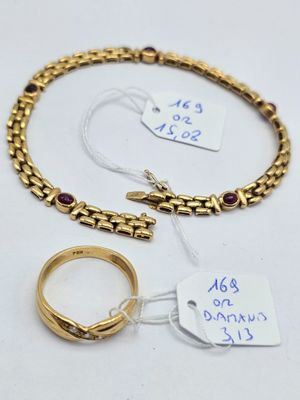 two gold bracelets and a ring are on a white surface