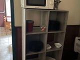un micro-ondes posé sur une bibliothèque dans une cuisine